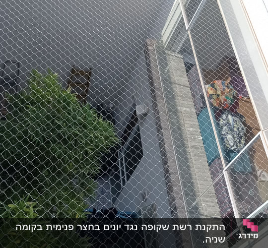 רשת מתכת מותקנת למניעת כניסת יונים למרפסת